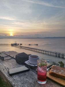 a drink on a table with a view of the ocean at Loti Guest House in Kupang