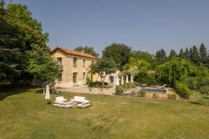 una casa con un patio con sillas y una piscina en La palasse, en Le Thor