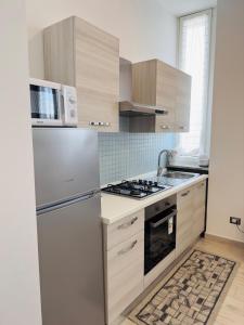 una cocina con estufa y microondas en Era apartments 2, en Caponago