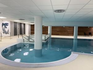 a swimming pool in a building with blue water at Résidence Le Portillo - Piscine - Studio pour 4 Personnes MAE-5293 in Gourette