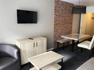 a living room with a couch and a tv on a wall at Résidence Le Portillo - Piscine - Studio pour 4 Personnes MAE-5303 in Gourette