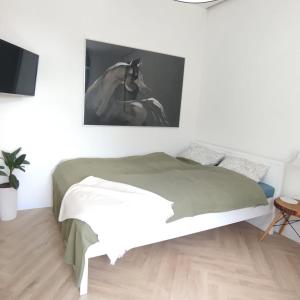 a bedroom with a bed and a painting of a horse at Apartment Rozbrat 5 in Wrocław