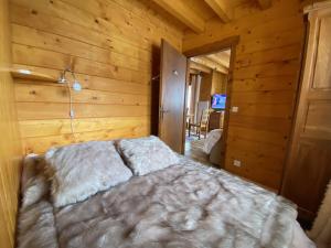 a bedroom with a bed in a wooden room at Chalet aux confins à proximité du télécabine de Balme in La Clusaz