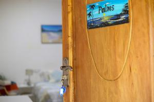 a door with a sign that reads palms on it at Shoraju Estate in Mchamba Wima