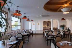 a restaurant with tables and chairs in a room at Orion Hotel in Faliraki