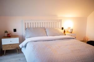 a bedroom with a large bed with a white bedspread at StyLove Domki 1 in Kluszkowce
