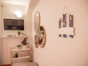 a room with two mirrors and a tv on a wall at Apartman Jakša in Hvar