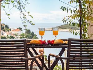 two glasses of orange juice on a table with two chairs at Apartman Jakša in Hvar