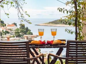 a table with two glasses of orange juice and fruit at Apartman Jakša in Hvar