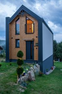 a house that is sitting in the grass at StyLove Domki 1 in Kluszkowce
