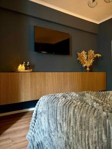 a bedroom with a bed with a television on the wall at My happy place - Apartment mit Sauna & Whirlpool in Essen