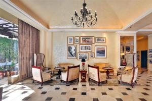 a lobby with a table and chairs and a chandelier at Villa Rosa Kempinski in Nairobi