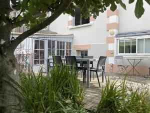 a patio with a table and chairs in front of a building at Maison arcachonnaise 3 ch., jardin, proche plage et commerces, WIFI - FR-1-433-129 in Arcachon