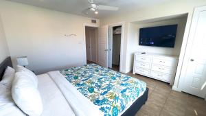 a bedroom with a bed and a flat screen tv at La Internacional 313 home in South Padre Island