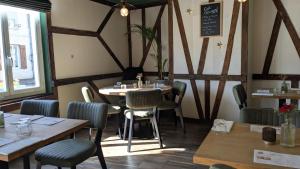 ein Esszimmer mit Holztischen und Stühlen in der Unterkunft L'Authentique in Beaumont-le-Roger + 24 Fotos
