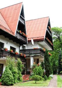 una casa con un tetto rosso e alcune piante di Willa Hamernik a Szczawnica