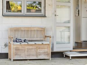 a wooden bench sitting in front of a door at Holiday Home Eikka - 100m from the sea by Interhome in Knebel