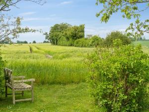 a bench sitting in the grass in a field at Holiday Home Ødke - 350m from the sea by Interhome in Odder