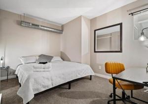 a bedroom with a bed and a table and a chair at Cleveland Vibes - Modern 2 BDR Apartment Downtown in Cleveland