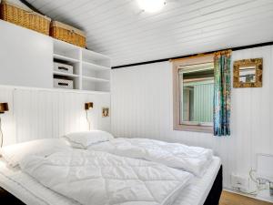 a large white bed in a room with a window at Holiday Home Spasena - 600m from the sea by Interhome in Løkken