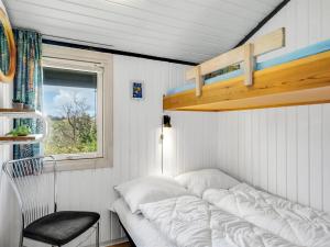 a bed in a small room with a window at Holiday Home Spasena - 600m from the sea by Interhome in Løkken