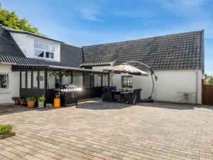 una casa con un patio al aire libre con sombrilla en Apartment Veronica - 700m from the sea by Interhome, en Saeby