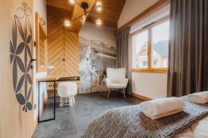 a bedroom with a bed and a desk and a chair at Czorsztyn Lux Apartments- apartament z prywatną sauną 292 in Kluszkowce