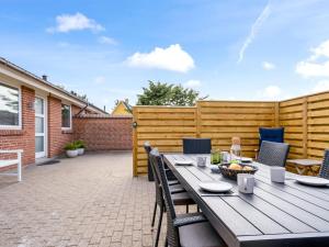 a patio with a wooden table and chairs at Holiday Home Sulo - 300m from the sea by Interhome in Blokhus