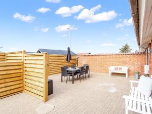 a patio with a wooden fence and a table and chairs at Holiday Home Sulo - 300m from the sea by Interhome in Blokhus