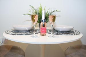 a white table with two champagne glasses on it at Modern Flat - Leeds City Centre in Central Station