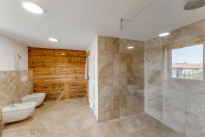 a bathroom with a shower and a toilet and a sink at Ferienwohnung Bergblick - stilvoll & modern im Grünen in Grünenbach +14 photos