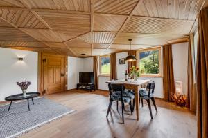 a dining room with a wooden ceiling and a table and chairs at Ferienwohnung Bergblick - stilvoll & modern im Grünen in Grünenbach