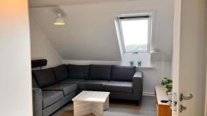 a living room with a couch and a window at Lejlighed i Esbjerg tæt på centrum og havn in Esbjerg