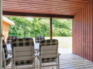 eine abgeschirmte Veranda mit Stühlen und einem Tisch in der Unterkunft Holiday Home Fritza - 500m from the sea by Interhome in Fårevejle