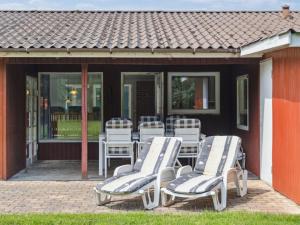 eine Gruppe von Stühlen und Tischen auf einer Terrasse in der Unterkunft Holiday Home Fritza - 500m from the sea by Interhome in Fårevejle