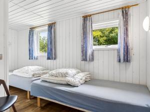 zwei Betten in einem Zimmer mit zwei Fenstern in der Unterkunft Holiday Home Fritza - 500m from the sea by Interhome in Fårevejle + 23 Fotos
