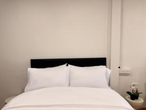 a white bed with white sheets and a black headboard at 豪华市中心联排别墅-暹罗百丽宫-siam in Pratunam +55 photos