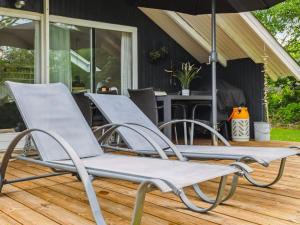 dos sillas sentadas en una cubierta bajo una sombrilla en Holiday Home Hereth - 30km from the sea by Interhome, en Toftlund