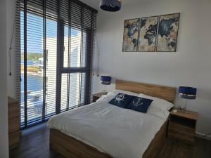Un dormitorio con una cama con dos almohadas azules encima. en Sol Marina Apartament Marina Blue, en Wiślinka