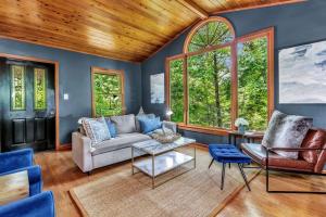 ein Wohnzimmer mit einer Couch und zwei Sesseln in der Unterkunft Cozy Serenity - Outdoor Hot Tub, Firepit, Games, + Close to Downtown Gatlinburg in Glade