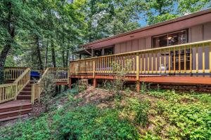ein Haus mit einer Terrasse und einer Treppe im Wald in der Unterkunft Cozy Serenity - Outdoor Hot Tub, Firepit, Games, + Close to Downtown Gatlinburg in Glade