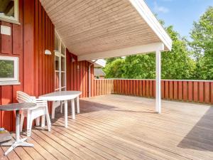 a deck with a table and chairs on a house at Holiday Home Bruna - 300m from the sea by Interhome in Jerup