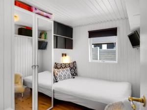 a small bedroom with a bed and a window at Holiday Home Reima - 50m from the sea by Interhome in Sæby