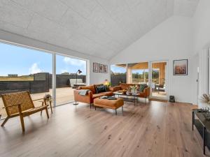 a living room filled with furniture and a large window at Holiday Home Dreng - 300m from the sea by Interhome in Harboør