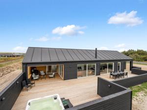 a modular house with a deck and a hot tub at Holiday Home Dreng - 300m from the sea by Interhome in Harboør