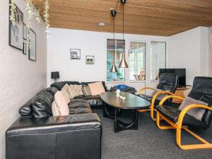 a living room with a leather couch and a table at Luxury Pool House in Vester Husby - By Traum Ferienwohnungen in Husby