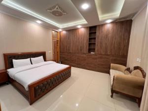 a bedroom with a bed and a chair in it at Cedar hills in Murree