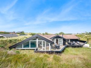 a house on the beach with a large deck at Holiday Home Emin - 700m from the sea by Interhome in Vejers Strand