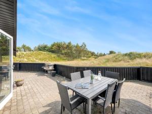 a wooden table and chairs on a patio at Holiday Home Emin - 700m from the sea by Interhome in Vejers Strand