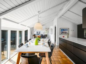 a kitchen and dining room with a white table and chairs at Holiday Home Emin - 700m from the sea by Interhome in Vejers Strand +23 photos
